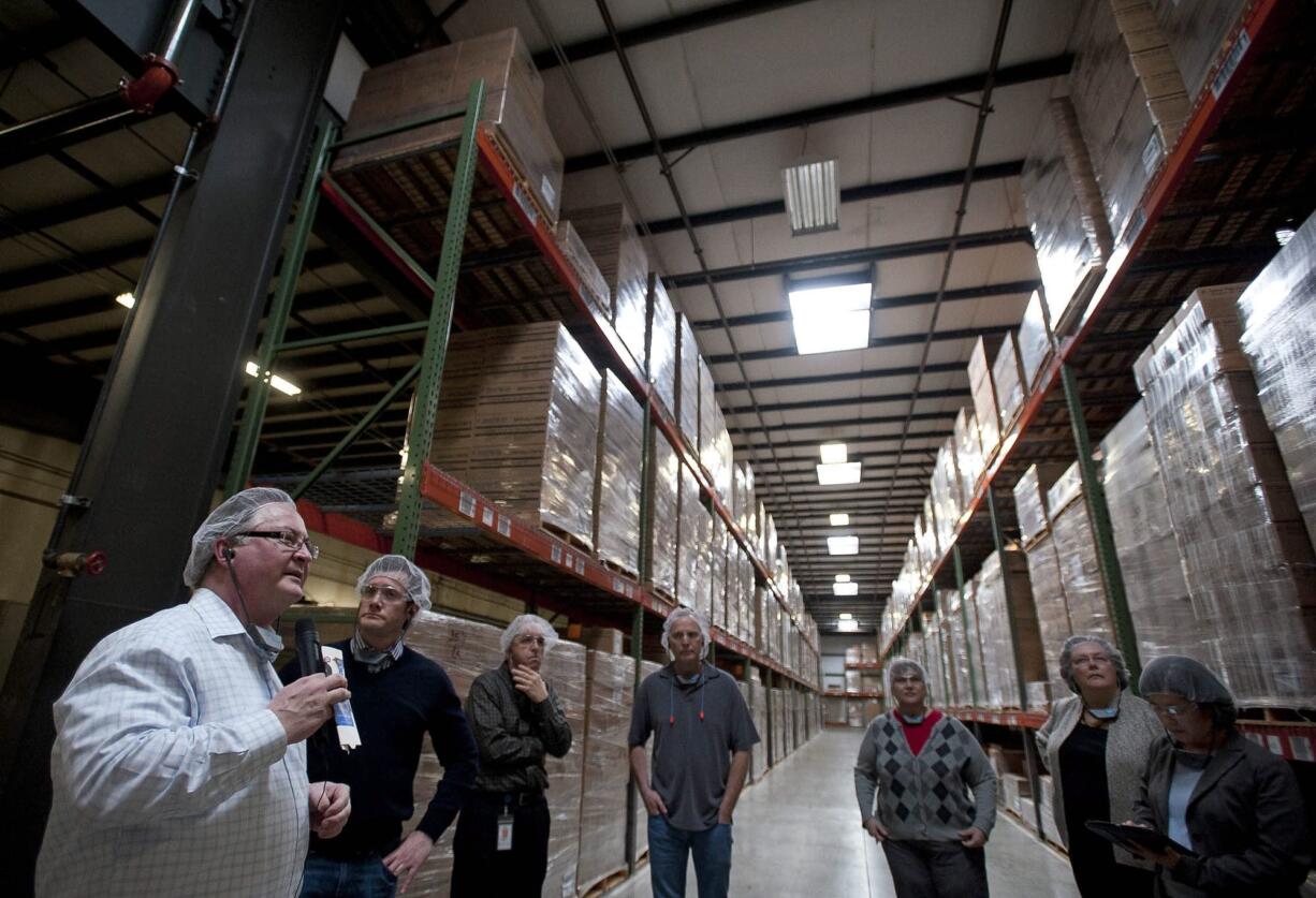 Tetra Pak Materials Factory Manager Robert Baker, left, leads Vancouver Mayor Tim Leavitt, second from left, and other officials on a tour Friday.