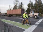 A cyclist traveling on state Highway 501 travels in a green bike lane near St. Francis Lane in Vancouver.