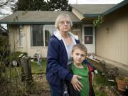 Lydia Mann of Vancouver, hugging her 6-year-old grandson, Aden Drum, fell behind on her mortgage payments and faces possible foreclosure.