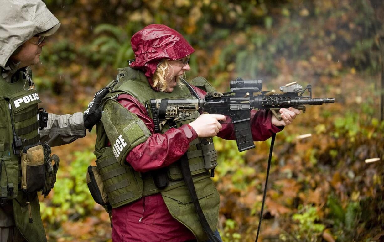 Columbian reporter Andrea Damewood experiences a Colt M4 Commando firsthand as the Southwest Washington SWAT team trains at the English Pit Shooting Range last week.