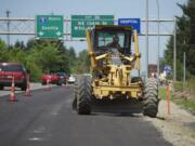 A grader driver on Monday puts the finishing touches on a new exit lane at the Northeast 134th Street exit off northbound Interstate 205. The lane is expected to open at 6 a.m.