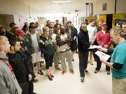 Applicants wait for their names to be called by Public Safety Testing's Bill Curtright, right, to find out if they passed the written portion of their test at Hudson's Bay High School on Feb. 12.