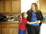 Laina Harris shares a moment with her 10-year-old son, Cameron, in the kitchen of the family's Camas home.