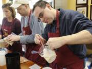 From left, Susan Chesley, Bob Ratz and Cory Vance prepare dinners to take home and cook later.