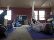 Julie Wiesner, background center, leads a group of girls through a recent Yoga Calm class at her home studio in Felida.