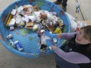 Terra Heilman, waste-reduction specialist with Waste Connections, explains which items are recyclable as she picks through the contents of a family's recycling bin Wednesday at the home of Tracy Davis.