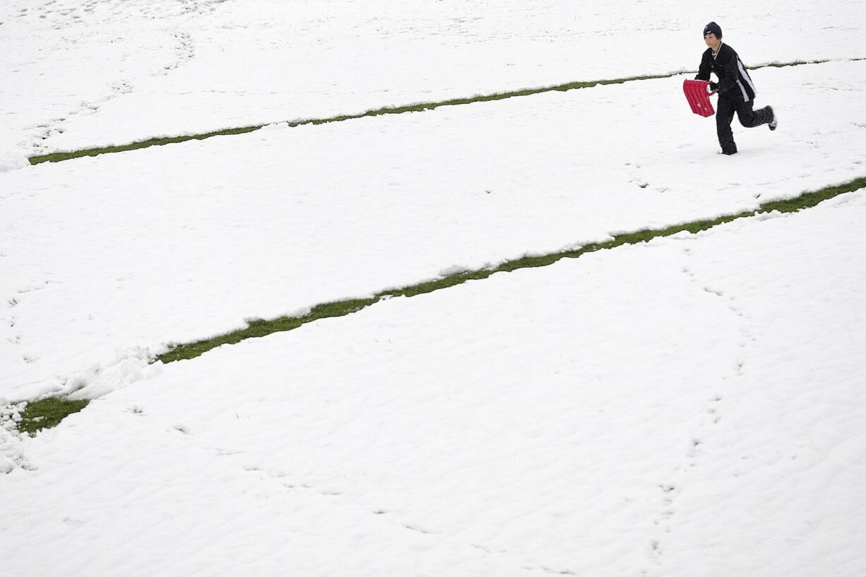 Carter Morse, 11, a student at Franklin Elementary School, enjoys a rare opportunity to go sledding in the snow Wednesday at Franklin Park in Vancouver.