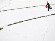 Carter Morse, 11, a student at Franklin Elementary School, enjoys a rare opportunity to go sledding in the snow Wednesday at Franklin Park in Vancouver.