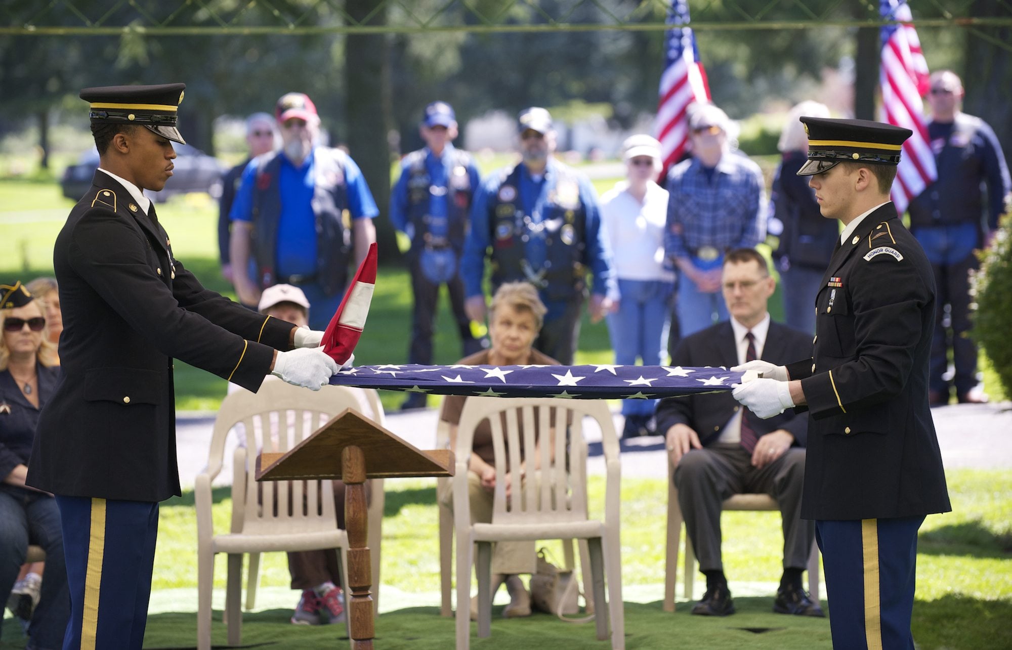 Army Spc. Karl Baker, left, and Spc. James Hanrahan fold a ceremonial flag Saturday at Evergreen Memorial Gardens during a memorial service for veterans who did not receive full military funerals at the time of their death.