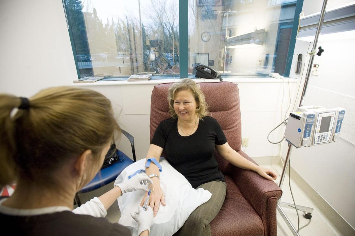 Registered nurse Betsy Roslyn inserts an IV as Sandy Schill of Ridgefield receives treatment at the Comprehensive Cancer Center at Legacy Good Samaritan Medical Center in Portland.