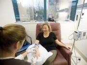 Registered nurse Betsy Roslyn inserts an IV as Sandy Schill of Ridgefield receives treatment at the Comprehensive Cancer Center at Legacy Good Samaritan Medical Center in Portland.