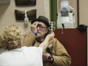 Suzanne Zamberlan of Evergreen Eye Care, left, checks the eyesight of Michael Kempf of Vancouver during Project Homeless Connect at St. Joseph Catholic Church.