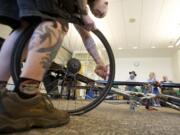 Wade Leckie of Bad Monkey Bikes, Board and Skate of Vancouver demonstrates how to fix a flat bicycle tire during a workshop at the Do-It-Yourself Fair at Clark College on Sunday.