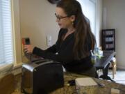 Megan Dugan runs household items through an energy meter that calculates electricity usage and corresponding charges at her home.