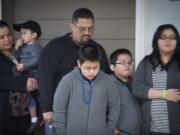 Lucrecia Tudela, left, and her husband, Cristino Cabrera, stand on the porch of their new home with their children (from left) Tyce, 2, Champ, 10, Ky, 7, and Ritaciah, 12, for a prayer at the dedication.