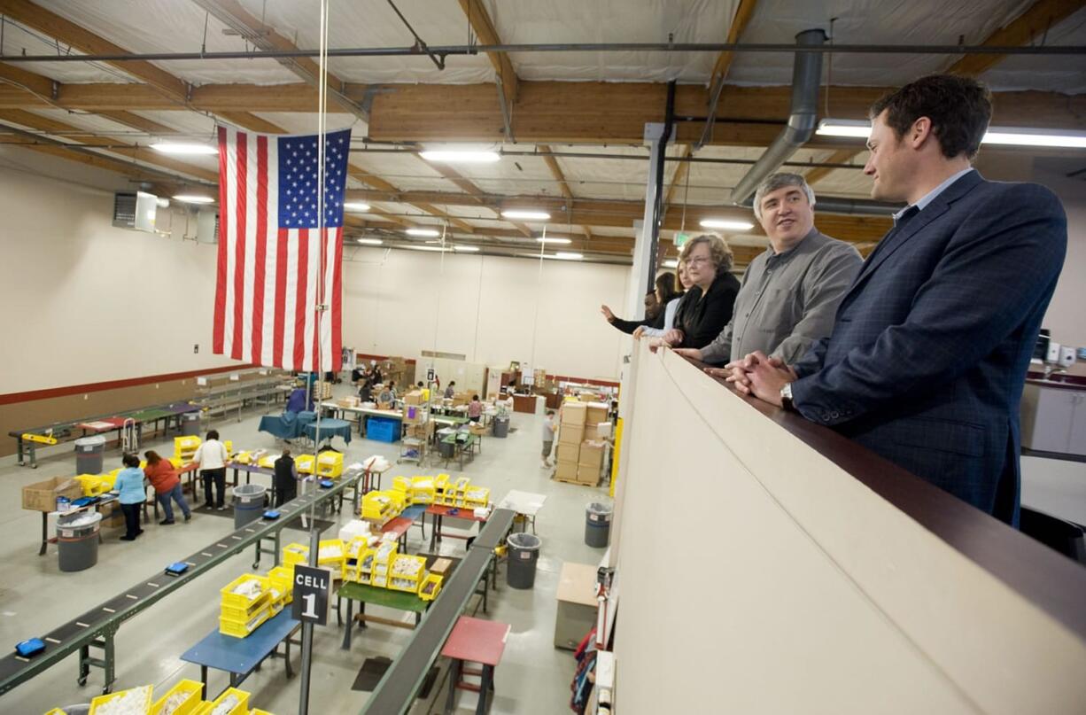 Lucas Reeves, second from right, operations manager of First Aid Only, gives a tour Monday of its facility to Columbia River Economic Development Council officials and Vancouver Mayor Tim Leavitt, right.