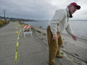 Paul Schwabe, a resident at the Tidewater Cove Condominiums, points out where the banks of the Columbia River are eroding, causing the indefinite closure of the Renaissance Trail.