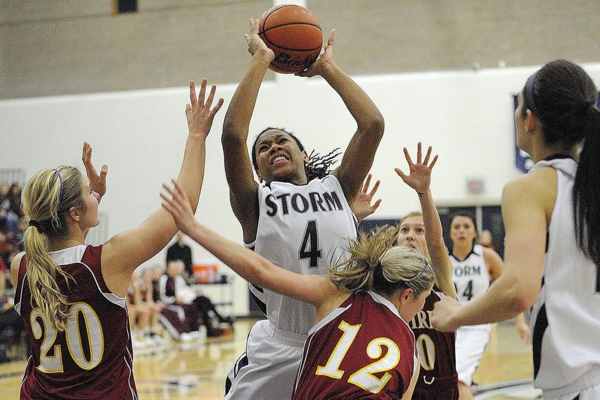 Jocelyn Adams, 4, of Skyview High School grabs an offensive rebound against Kelsey Asplund, 20, left, and Cori Woodward, 12, of Prairie High School during a game December 5, 2011 in Vancouver, Washington. Skyview beat Prairie 48-33.