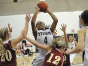 Jocelyn Adams, 4, of Skyview High School grabs an offensive rebound against Kelsey Asplund, 20, left, and Cori Woodward, 12, of Prairie High School during a game December 5, 2011 in Vancouver, Washington. Skyview beat Prairie 48-33.