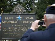 Rev. Jerry L. Keesee takes a photograph of the Blue Star Memorial Highway marker that was refurbished after vandals damaged it, during a re-dedication ceremony on Monday June 21, 2010.