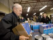 Volunteer Joe Smith, 76, stacks the mac-n-cheese that will help feed hungry kids through the Share Backpack Program.