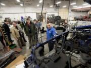 Photos by Steven Lane/The Columbian
Dick Hannah Collision Center Director Rick Stoker, center, gives a tour of the body shop to a group of Washington State University Vancouver students and OMSI representatives working on an exhibit for the Portland museum.