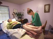 Jowanna Harman-Stever, right, of New Harmony Health in Vancouver, provides acupuncture treatment to patient Virginia Barber, 80, recently.