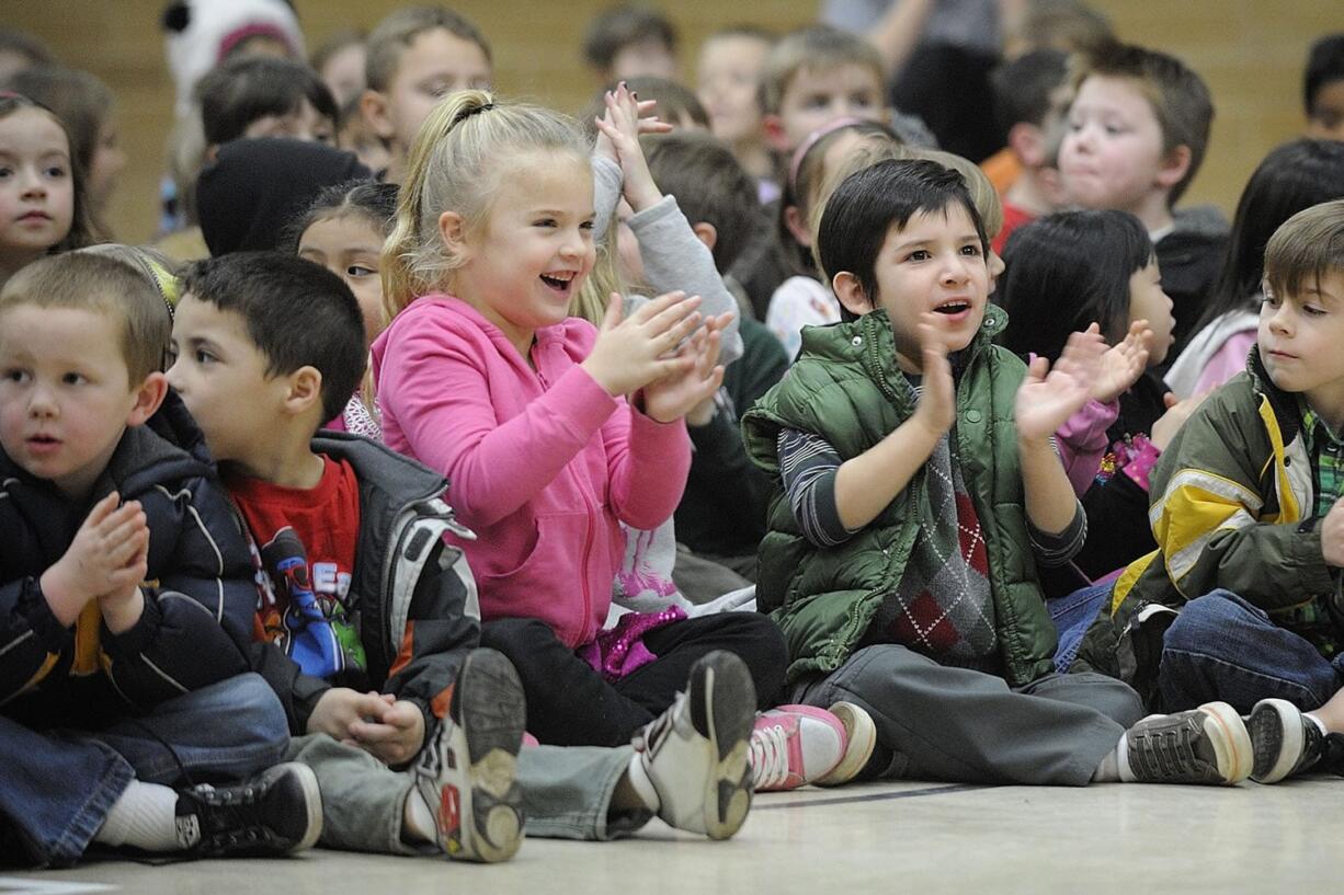 Elyse Krout, center in pink, and Noah Alfter, wearing green, kindergartners at Pleasant Valley Primary School, cheer for the cast of &quot;Hansel and Gretel.&quot;