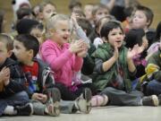 Elyse Krout, center in pink, and Noah Alfter, wearing green, kindergartners at Pleasant Valley Primary School, cheer for the cast of &quot;Hansel and Gretel.&quot;