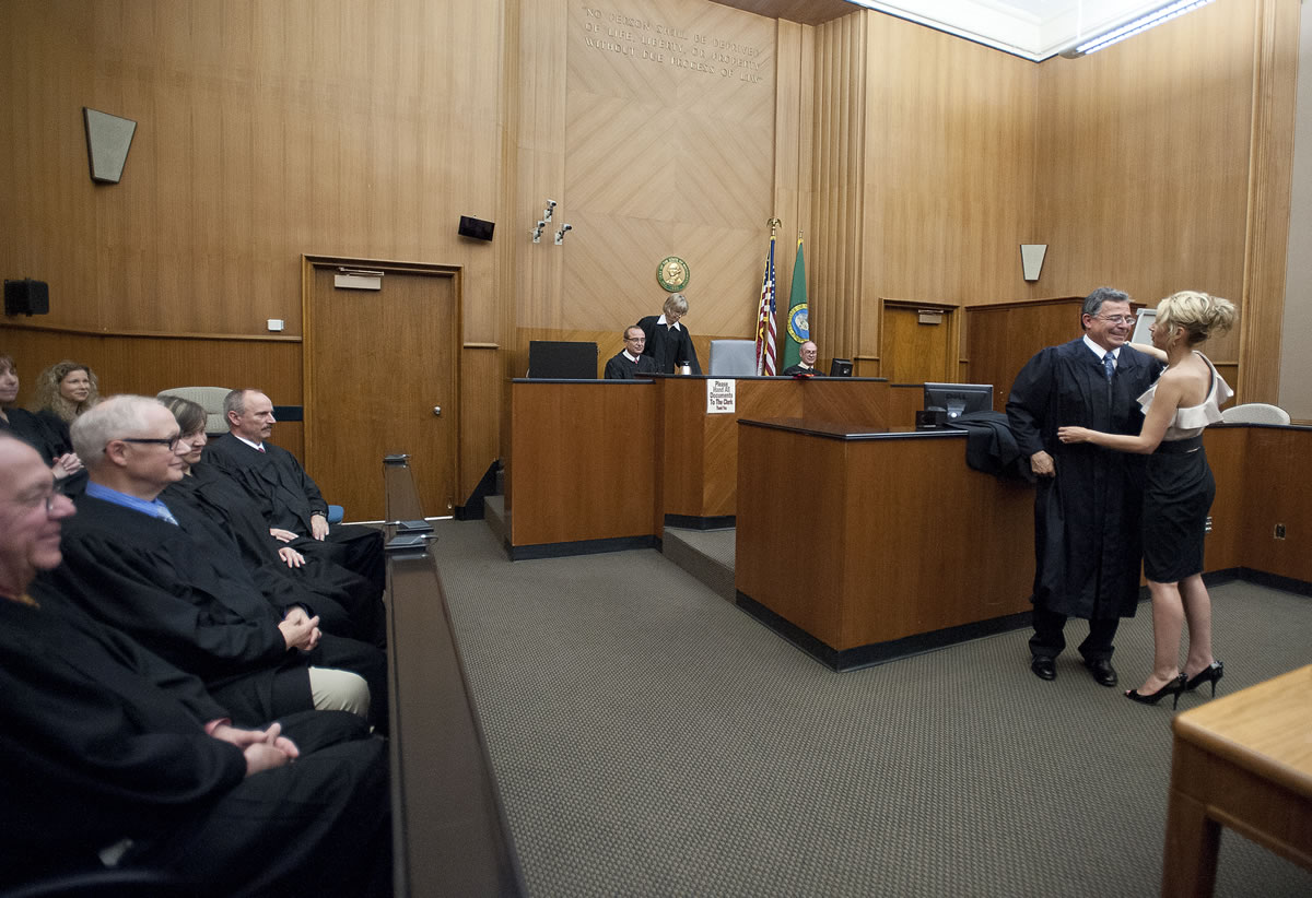 Gregory Gonzales, the new Superior Court judge, is helped into his robes by his fiancee Molly Trafelet after a swearing-in ceremony Friday afternoon in Presiding Judge Barbara Johnson's courtroom.