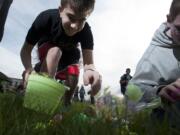 Washington State School for the Blind students (from left) Tanner Deck, 14, and Gabe Markstrom, 17, grab candy during the annual Easter egg hunt.