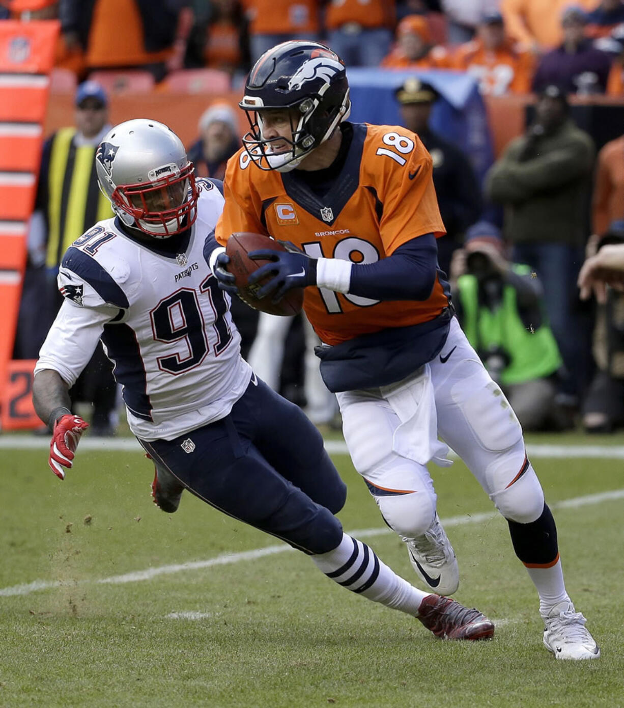 Denver Broncos quarterback Peyton Manning evades a tackle by New England Patriots outside linebacker Jamie Collins (91) during the first half of the NFL football AFC Championship game between the Denver Broncos and the New England Patriots, Sunday, Jan. 24, 2016, in Denver.