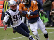 Denver Broncos quarterback Peyton Manning evades a tackle by New England Patriots outside linebacker Jamie Collins (91) during the first half of the NFL football AFC Championship game between the Denver Broncos and the New England Patriots, Sunday, Jan. 24, 2016, in Denver.