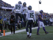 Seattle Seahawks wide receiver Doug Baldwin (89) and quarterback Russell Wilson (3) celebrate a touchdown as wide receiver Jermaine Kearse (15) joins during the second half of an NFL wild-card football game against the Minnesota Vikings, Sunday, Jan. 10, 2016, in Minneapolis. (AP Photo/Nam Y.