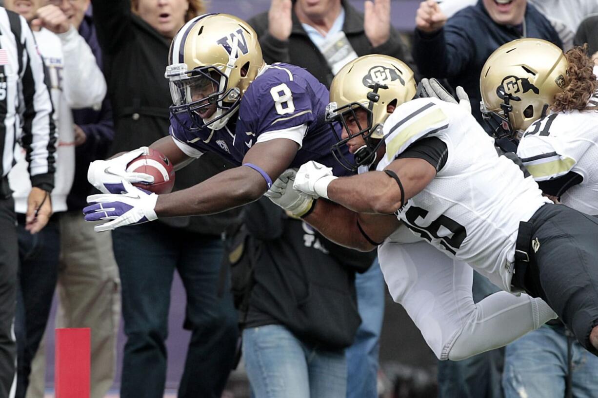 Washington's Kevin Smith (8) dives into the end zone on a 22-yard touchdown carry as Colorado's Tony Jones defends on in the first half Saturday.