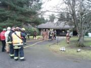 Firefighters watch as a mop-up takes place after a Thursday afternoon fire at 17407 N.E.