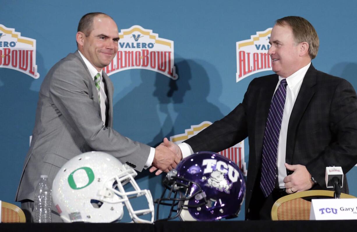 Oregon head coach Mark Helfrich, left, and TCU head coach Gary Patterson, right, shake hands following a news conference for the Alamo Bowl NCAA college football game, Friday, Jan. 1, 2016, in San Antonio. The two teams meet on Saturday.