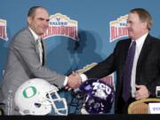 Oregon head coach Mark Helfrich, left, and TCU head coach Gary Patterson, right, shake hands following a news conference for the Alamo Bowl NCAA college football game, Friday, Jan. 1, 2016, in San Antonio. The two teams meet on Saturday.