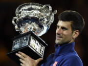 Novak Djokovic of Serbia holds his trophy aloft after defeating Andy Murray of Britain in the men's singles final at the Australian Open tennis championships in Melbourne, Australia, Sunday, Jan.