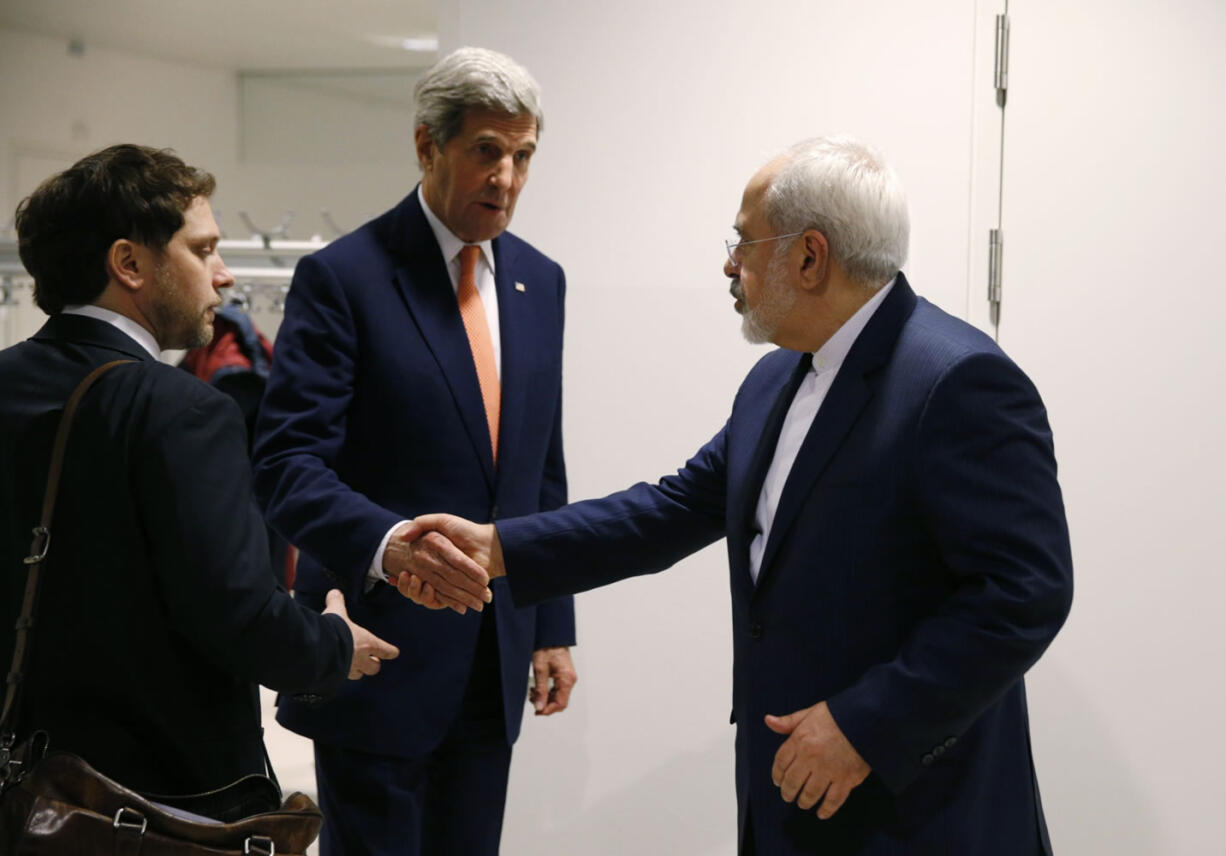 U.S. Secretary of State John Kerry shakes hands with Iranian Foreign Minister Mohammad Javad Zarif, right, after the International Atomic Energy Agency verified that Iran has met all conditions under the nuclear deal, in Vienna, Austria, on Saturday. U.S. Secretary of State, John Kerry confirms Iran in compliance with nuclear deal and lifts US nuclear-related sanctions.