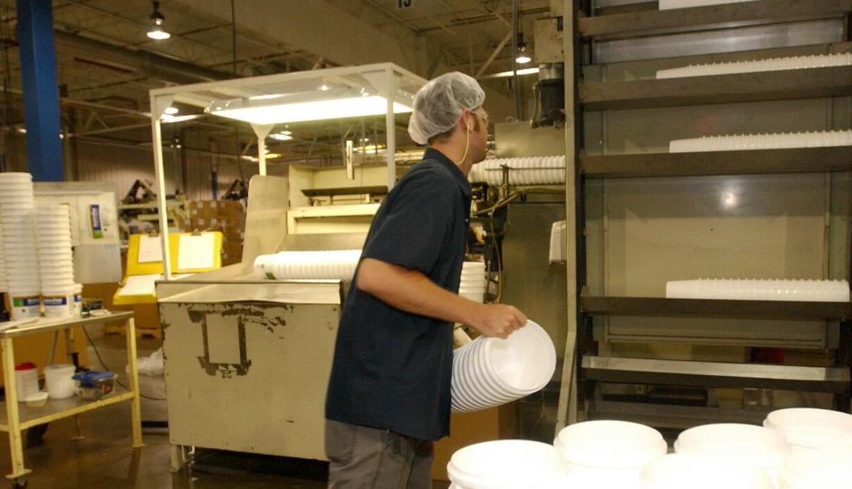 Berry Plastics Corporation's Vancouver operations will be transferred to Berry facilities in Wisconsin, Indiana and Georgia. The company said it announced on Nov. 3 that it would close the Vancouver plant on or about Jan. 3. Here, an employee loaded blank white plastic containers into a machine to be printed at Berry Plastics in Evansville, Ind. (AP Photo/ Daniel R.