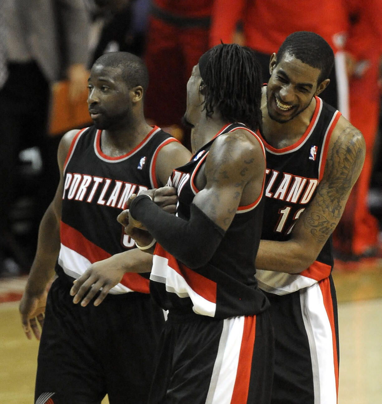 Portland Trail Blazers' LaMarcus Aldridge (12) celebrates with teammates Gerald Wallace, center, and Raymond Felton, left, as they go on to defeat the Washington Wizards 110-99 on Saturday.