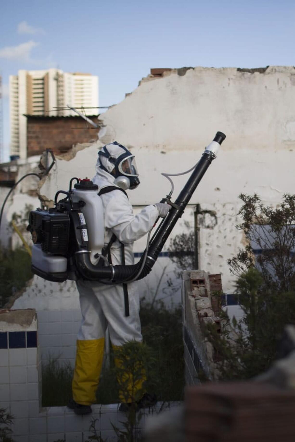 In this Jan. 26, 2016 photo, a municipal worker sprays insecticide to combat the Aedes aegypti mosquitoes that transmit the Zika virus, at the Imbiribeira neighborhood in Recife, Pernambuco state, Brazil. Brazil once succeeded in eliminating the Aedes, which is well adapted to humans, lives within people?s homes and can breed in just a bottle cap of stagnant water.