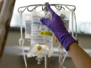 A nurse places a patient&#039;s chemotherapy medication on an intravenous stand at a hospital in Philadelphia.