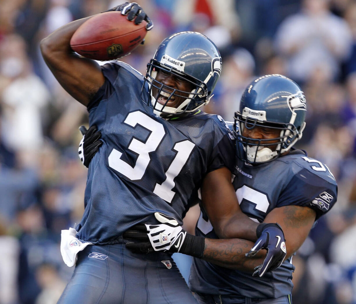 Seattle's Kam Chancellor (31) celebrates with Leroy Hill after an interception to help seal the victory against Arizona on Sunday.