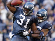 Seattle's Kam Chancellor (31) celebrates with Leroy Hill after an interception to help seal the victory against Arizona on Sunday.