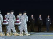 An Army carry team carries the transfer case containing the remains of Army Staff Sgt. Matthew Q. McClintock of  Bernalillo, N.M. as from left, U.S. congresmen Jim McDermott, D-Wash, Derek Kilmer, D-Wash. and Army Under Secretary Patrick Murphy salute, upon arrival at Dover Air Force Base, Del. on Friday.