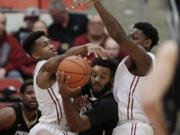 Colorado's Tre'Shaun Fletcher, center, goes after a rebound against Washington State's Ny Redding, left, and Robert Franks during the first half of an NCAA college basketball game Saturday, Jan. 23, 2016, in Pullman, Wash.