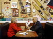 Democratic presidential candidate Hillary Clinton, left, chats with Sen. Cory Booker, D-N.J., Sunday at Riley&#039;s Cafe in Cedar Rapids, Iowa.