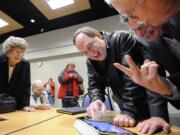 Val Ogden, left, watches as Jack Burkman, Ron Onslow, mayor of Ridgefield, and Brian Wolfe, port commissioner, look over election results at Gaiser Hall at Clark College Tuesday November 8, 2011 in Vancouver, Washington.